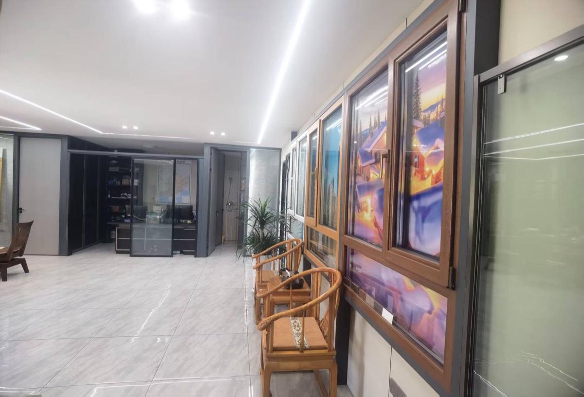 哈尔滨米格门业断桥铝门窗展示区：多款窗型样品、中空玻璃、实木椅与现场洽谈空间